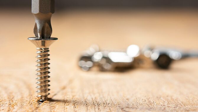 Screws screwed into wooden plank stock photo. Screws close up on wooden table